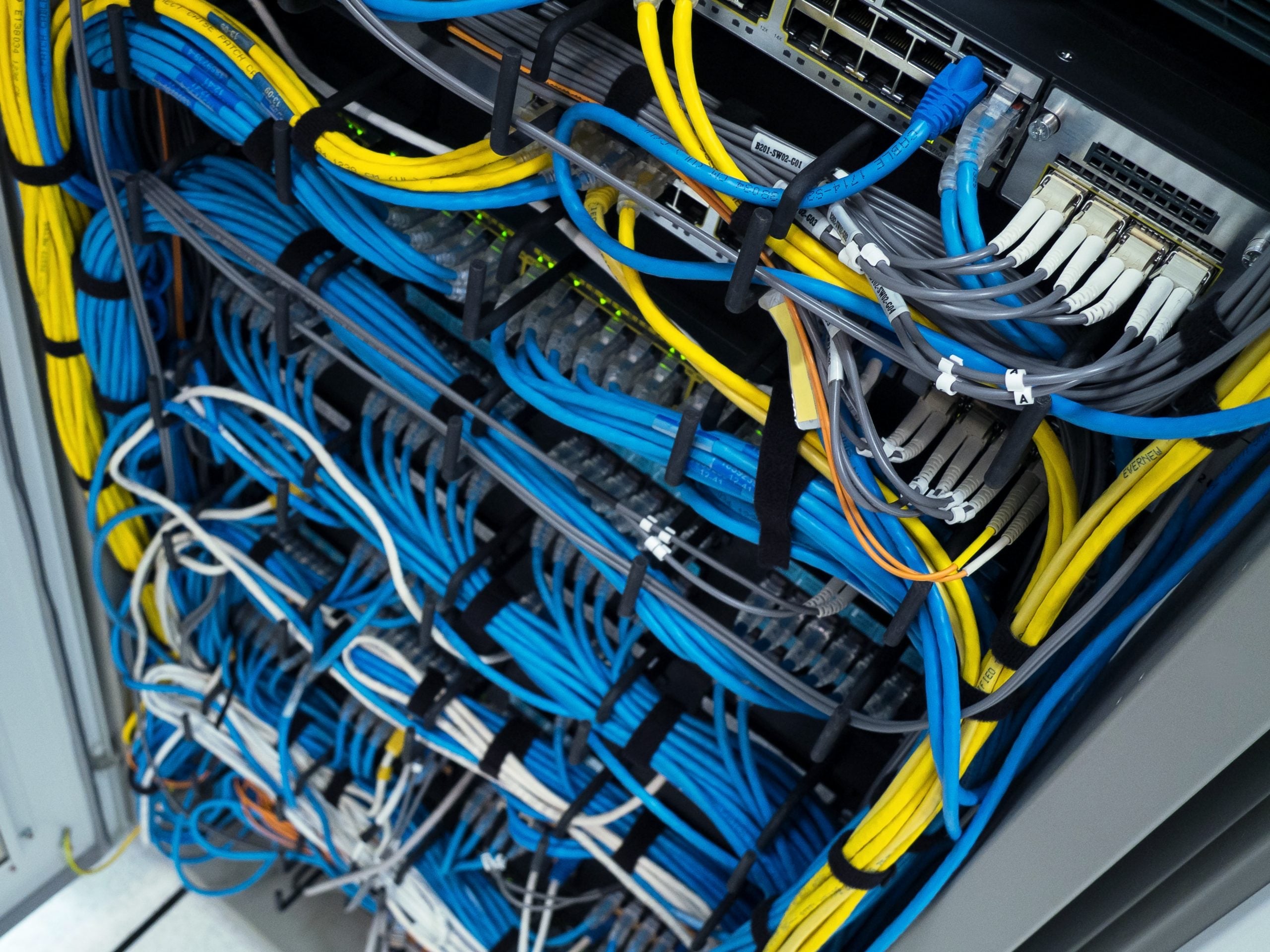 Neatly organized structured cabling rack with Cat6 patch panels and network switches in an Orlando IT closet